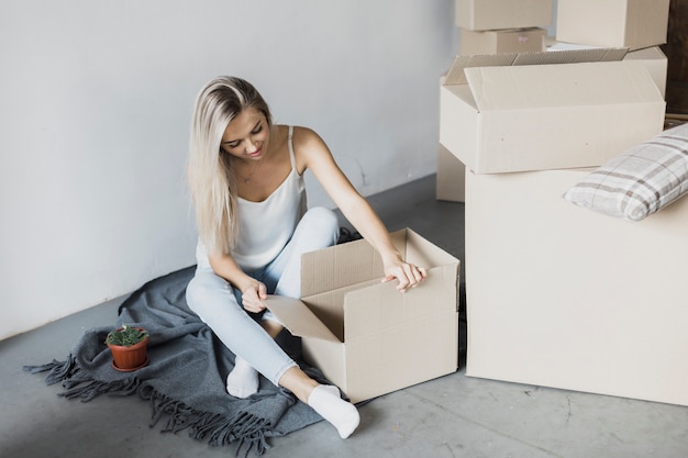 Mujer joven con cajas en el piso