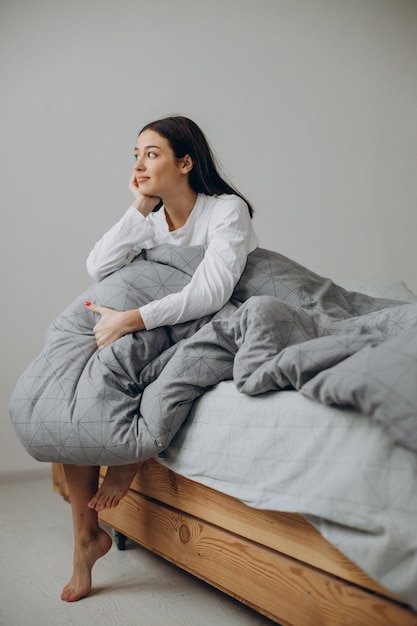 Mujer joven, en cama, por la mañana