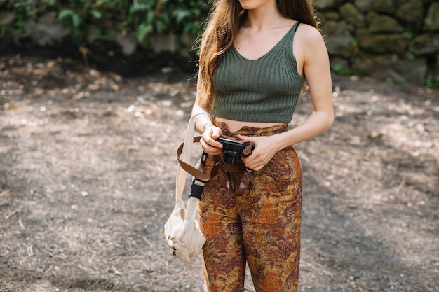 Mujer joven con una cámara en la naturaleza