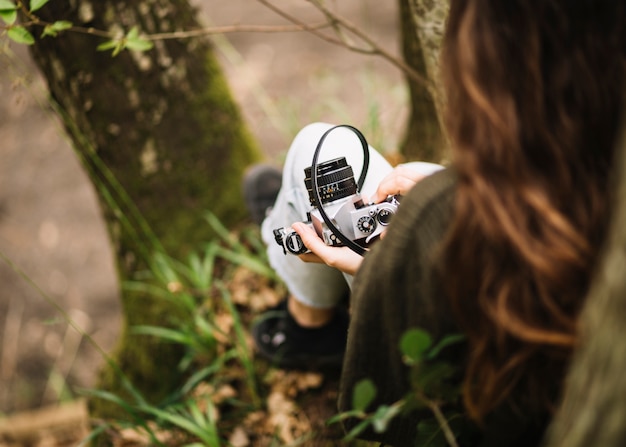 Mujer joven con una cámara en la naturaleza