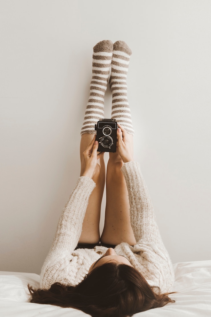 Foto gratuito mujer joven con cámara retro cerca de la pared