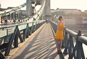 Foto gratuita mujer joven camina sobre el puente en budapest