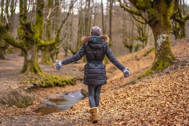 Foto gratuita mujer joven caminando en el bosque de otzarreta en el parque natural de gorbea, bizkaia, país vasco