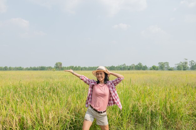 Mujer joven caminando en el campo de arroz en Tailandia. Viajar a lugares limpios de la Tierra y descubrir la belleza de la naturaleza. Viajero joven con sombrero de pie.