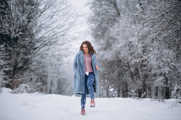 Mujer joven caminando en un parque de invierno