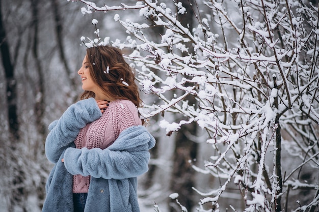 Mujer joven caminando en un parque de invierno