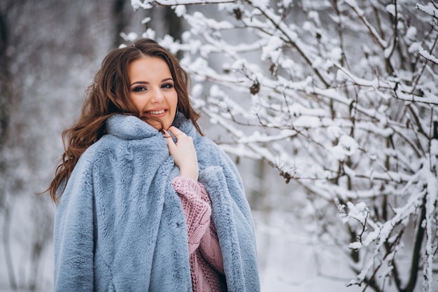 Mujer joven caminando en un parque de invierno