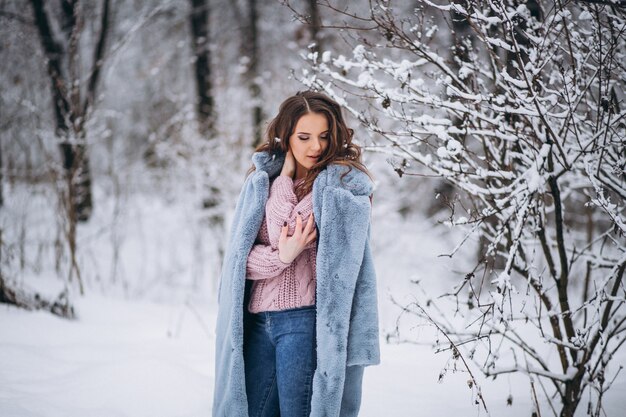 Mujer joven caminando en un parque de invierno