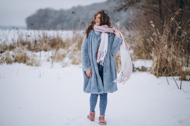 Mujer joven caminando en un parque de invierno