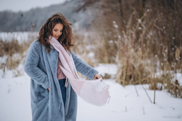 Mujer joven caminando en un parque de invierno