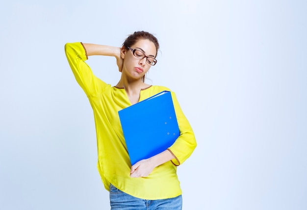 Foto gratuita mujer joven con camisa amarilla se ve pensativa y soñadora