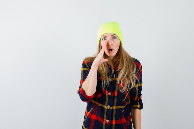 Mujer joven en una camisa a cuadros con un sombrero