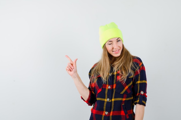 Foto gratuita mujer joven en una camisa a cuadros con un sombrero