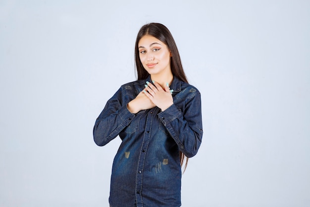 Mujer joven en camisa de mezclilla sonriendo y haciendo cara bonita