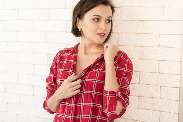 Mujer joven con camisa roja mirando hacia un lado