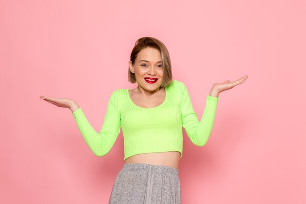 mujer joven, en, camisa verde, y, falda gris, sonriente, posar