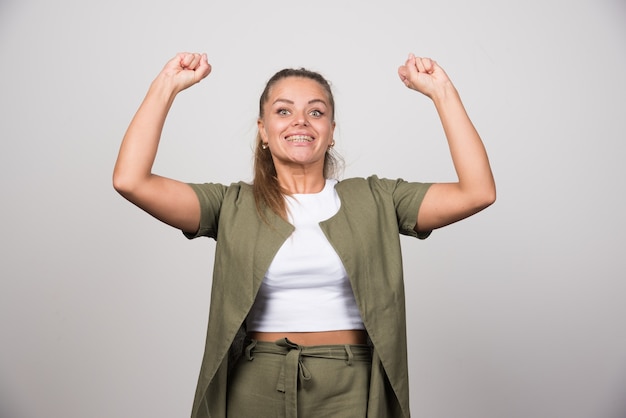 Mujer joven en camisa verde sintiéndose feliz.