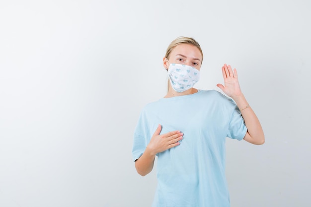 Mujer joven en una camiseta azul con una máscara médica