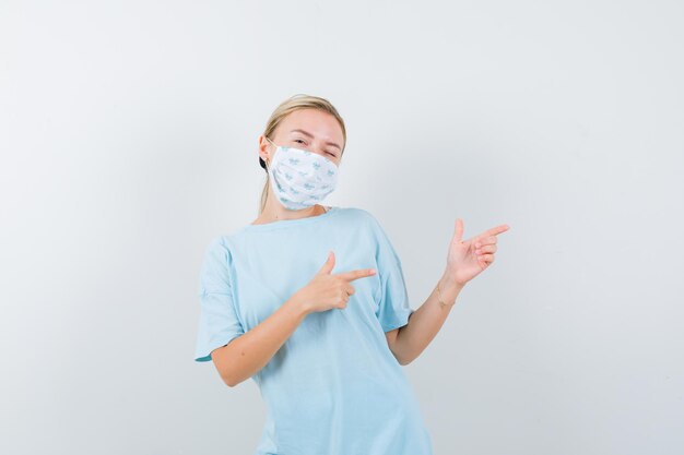 Mujer joven en una camiseta azul con una máscara médica