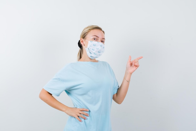 Mujer joven en una camiseta azul con una máscara médica