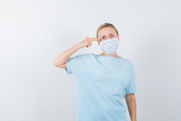 Mujer joven en una camiseta azul con una máscara médica