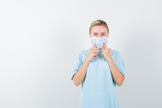 Mujer joven en una camiseta azul con una máscara médica