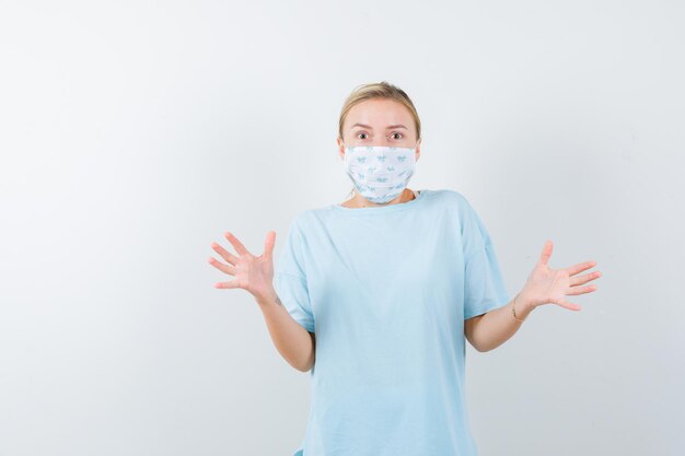 Mujer joven en una camiseta azul con una máscara médica