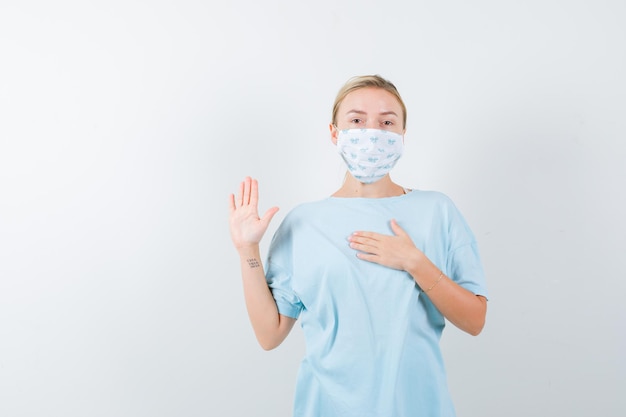 Mujer joven en una camiseta azul con una máscara médica