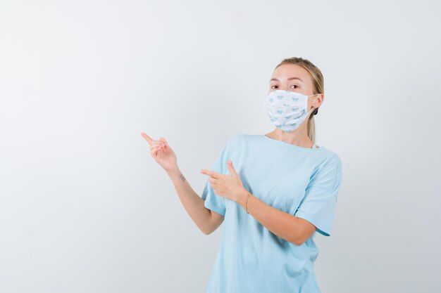 Mujer joven en una camiseta azul con una máscara médica