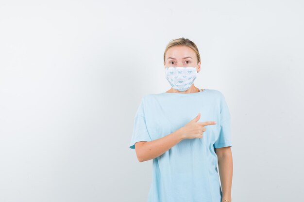 Mujer joven en una camiseta azul con una máscara médica