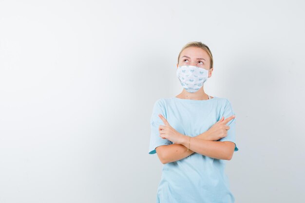 Mujer joven en una camiseta azul con una máscara médica