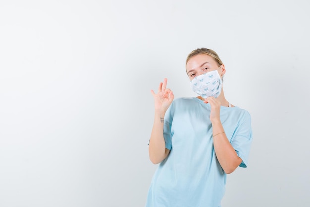 Mujer joven en una camiseta azul con una máscara médica