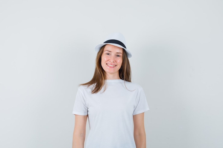 Foto gratuito mujer joven con camiseta blanca, sombrero y alegre.
