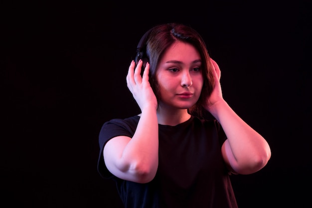 Mujer joven con camiseta negra con auriculares