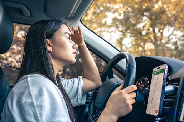 Foto gratuita mujer joven y cansada conductora de coche que sufre de migraña y dolor de cabeza conduciendo un vehículo