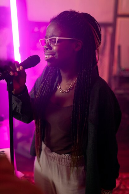 Mujer joven cantando en un evento local.