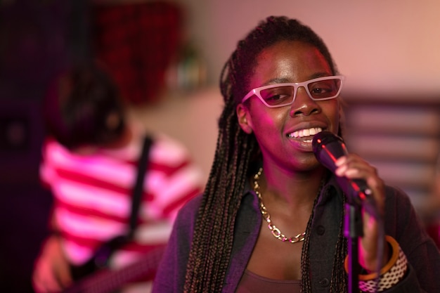 Mujer joven cantando en un evento local.