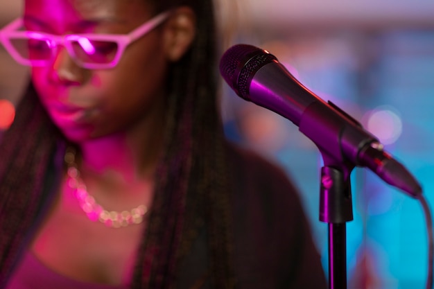 Mujer joven cantando en un evento local.