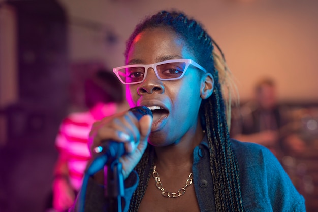 Mujer joven cantando en un evento local.