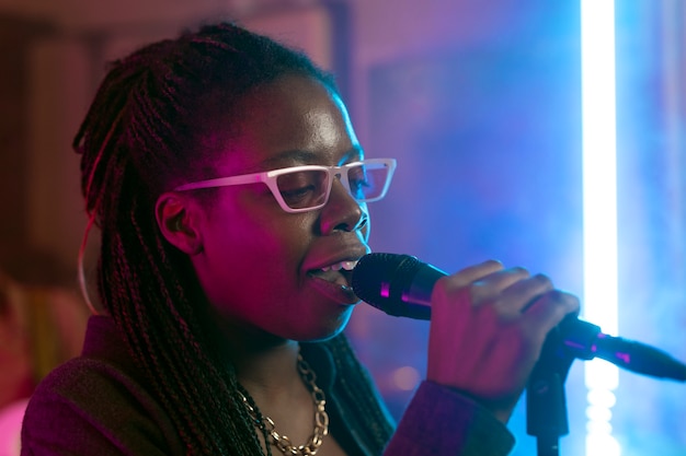 Mujer joven cantando en un evento local.