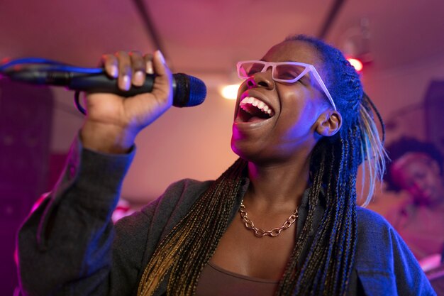 Mujer joven cantando en un evento local.