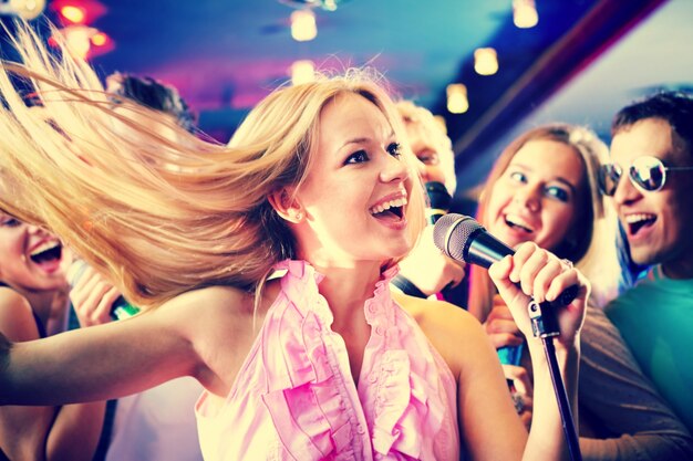 Mujer joven cantando en una fiesta