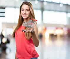 Foto gratuita mujer joven con un carrito de la compra en el fondo blanco