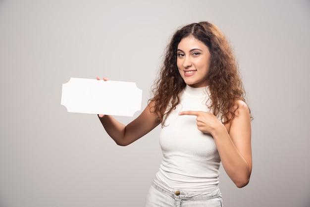 Mujer joven con cartel de discurso blanco en blanco vacío. Foto de alta calidad