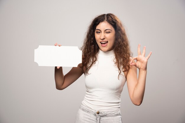 Mujer joven con cartel de discurso blanco en blanco vacío. Foto de alta calidad