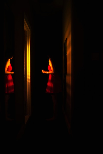 Mujer joven en casa con misteriosas luces interiores