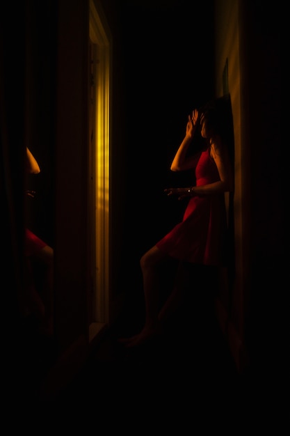 Mujer joven en casa con misteriosas luces interiores