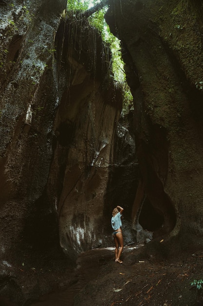 mujer joven en la cascada en la roca Bali Indonesia