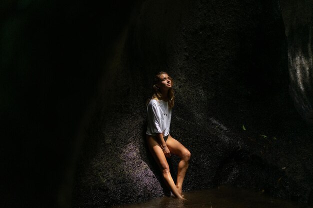 mujer joven en la cascada en la roca Bali Indonesia
