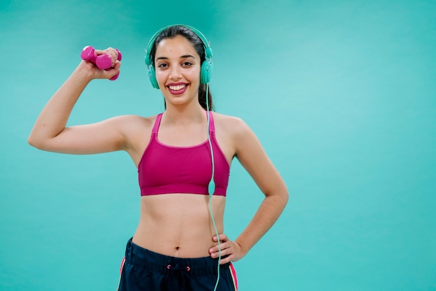 Mujer joven con cascos y mancuerna